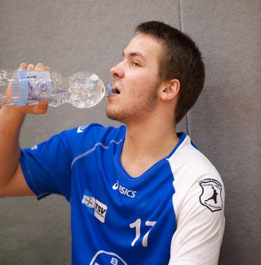 Junger Mann trinkt aus einer Wasserflasche